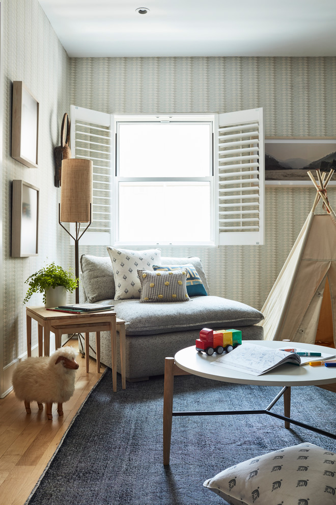 This is an example of a medium sized contemporary gender neutral kids' bedroom in New York with beige walls, light hardwood flooring and brown floors.
