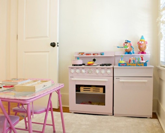 Cette image montre une petite chambre d'enfant de 4 à 10 ans traditionnelle avec un mur blanc et un sol en bois brun.