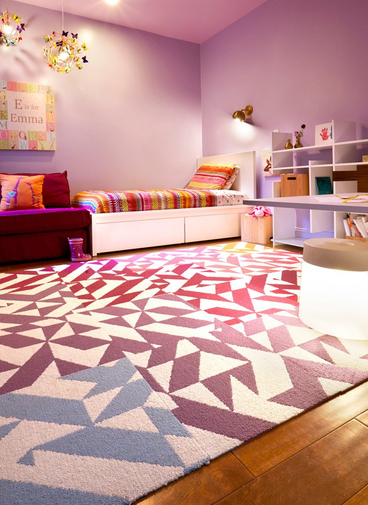 Ejemplo de dormitorio infantil de 4 a 10 años minimalista con paredes púrpuras y suelo de madera en tonos medios