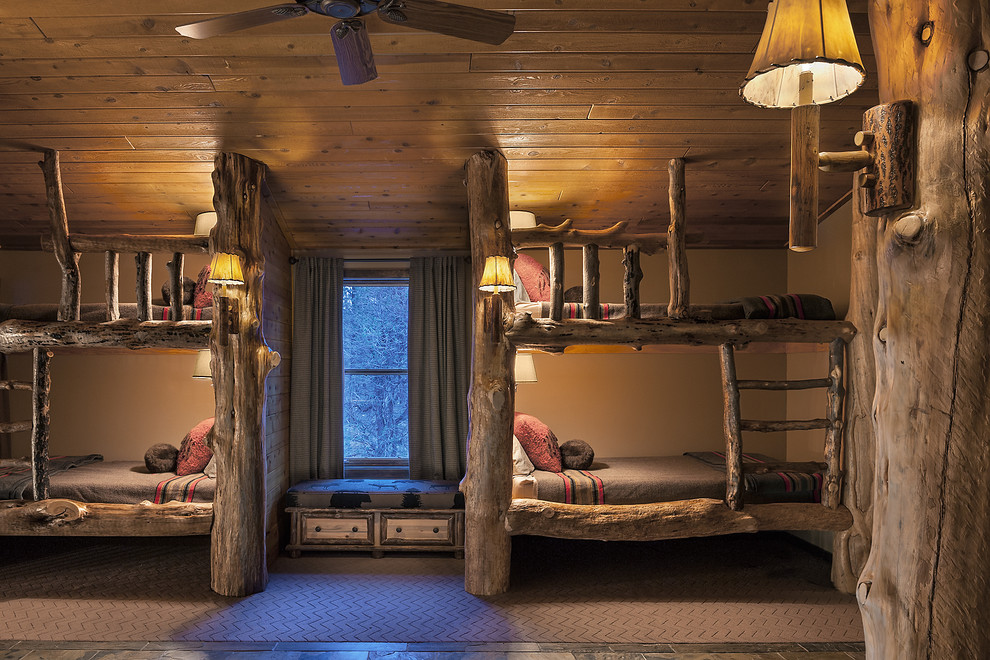 Exemple d'une grande chambre d'enfant montagne avec un mur beige, un sol en ardoise, un sol marron et un lit superposé.