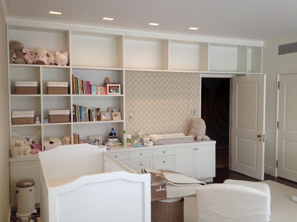 Photo of a large contemporary gender neutral toddler’s room in New York with white walls, medium hardwood flooring and brown floors.