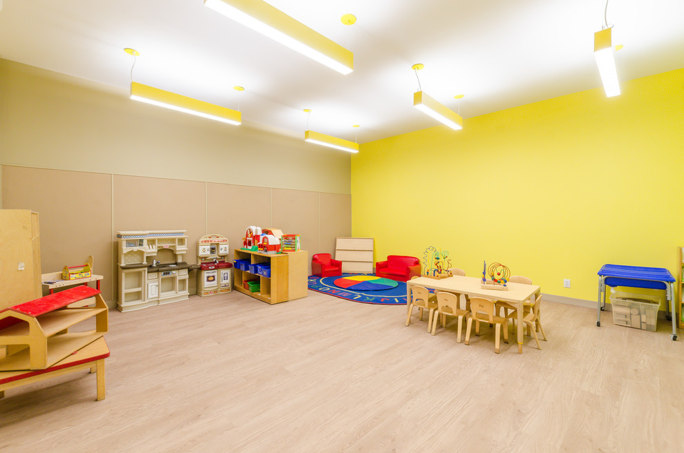 Réalisation d'une petite chambre d'enfant de 1 à 3 ans design avec un mur jaune, sol en stratifié et un sol beige.