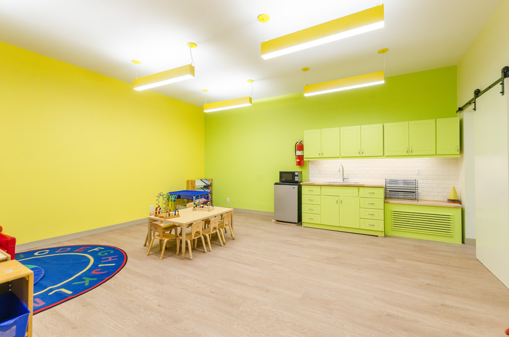 Aménagement d'une petite chambre d'enfant de 1 à 3 ans contemporaine avec un mur jaune, sol en stratifié et un sol beige.
