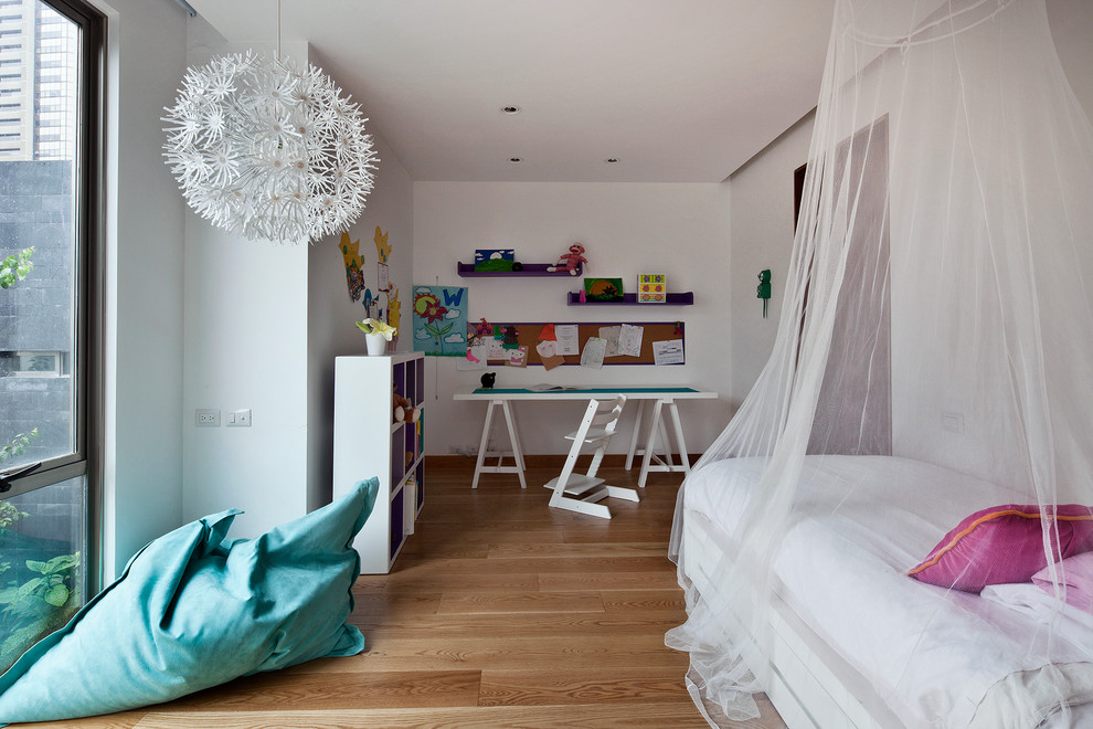 Trendy girl medium tone wood floor kids' room photo in Mexico City with white walls
