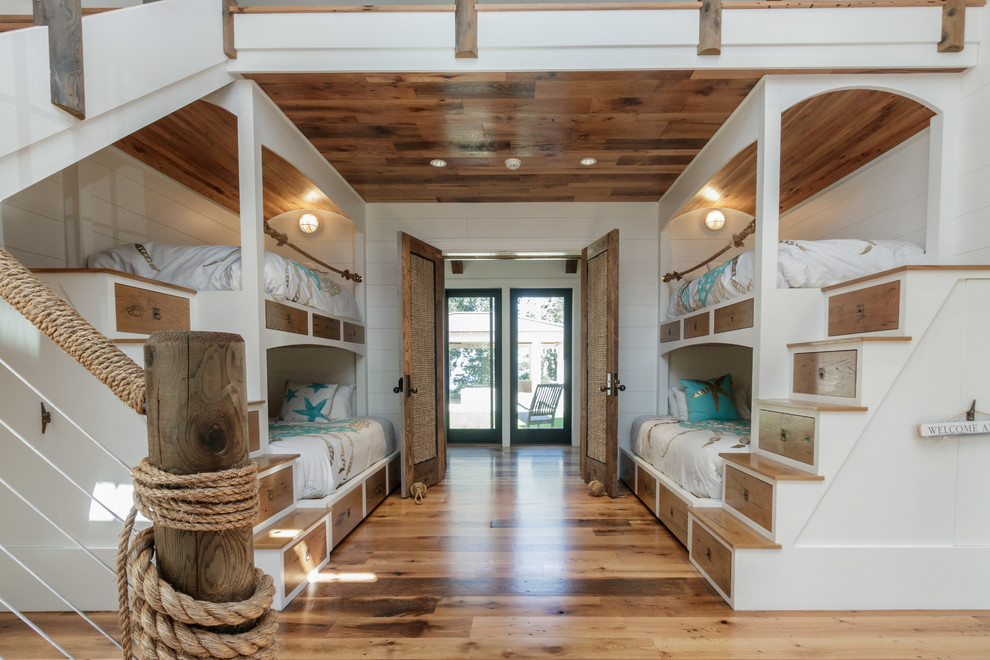 Maritimes Kinderzimmer mit Schlafplatz, weißer Wandfarbe, braunem Holzboden und braunem Boden in Boston