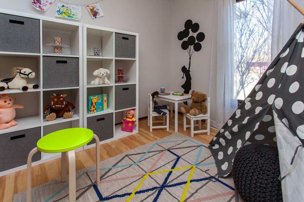 Foto di una cameretta per bambini da 1 a 3 anni design con pareti grigie e parquet chiaro