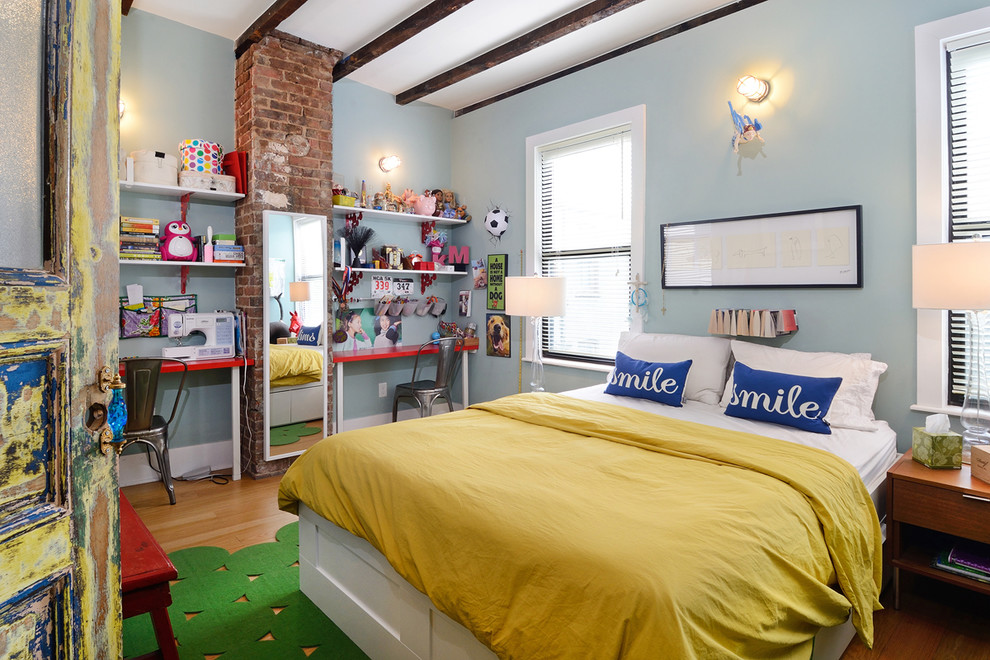 Cette photo montre une chambre d'enfant éclectique avec un mur bleu et un sol en bois brun.
