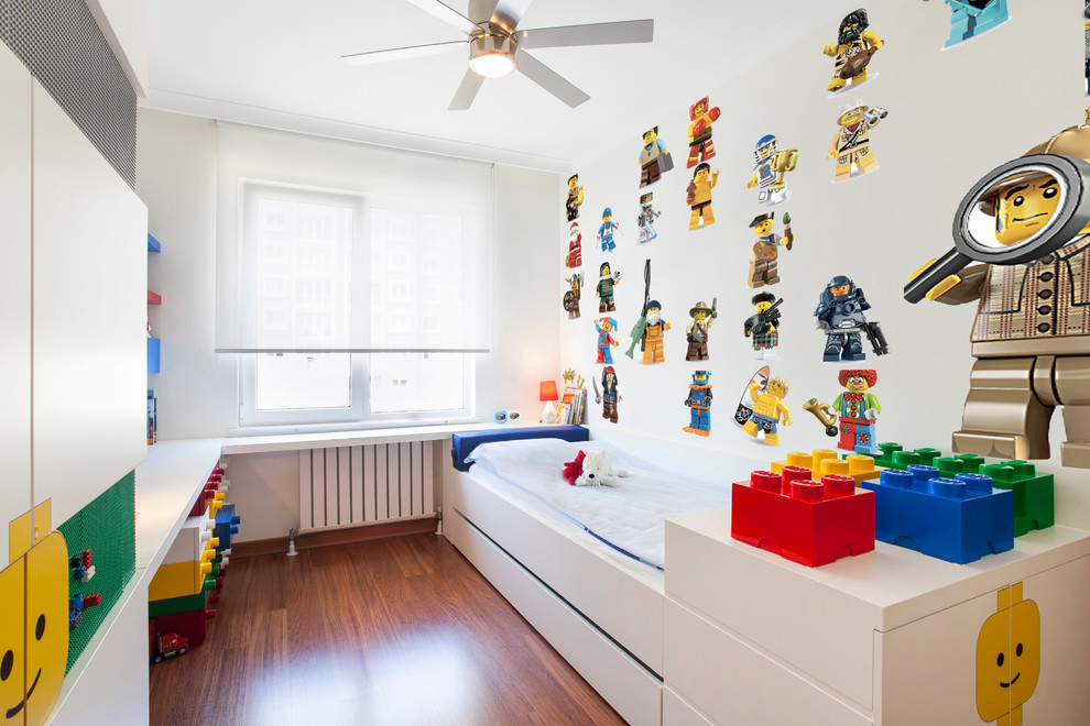 Esempio di una cameretta per bambini da 1 a 3 anni minimal con pareti bianche e pavimento in legno massello medio