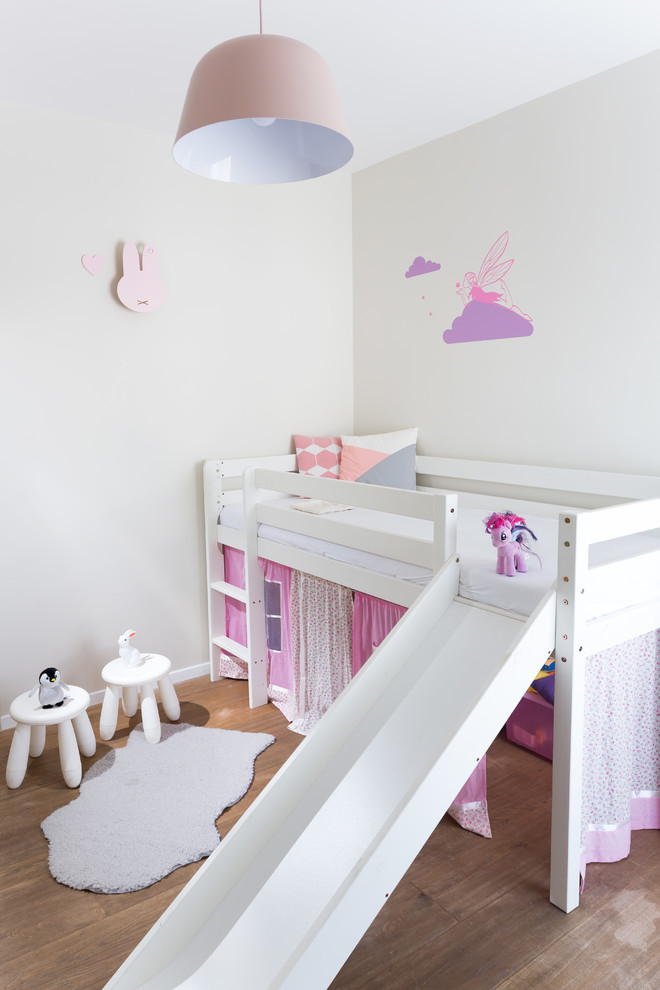 Exempel på ett modernt barnrum kombinerat med sovrum, med beige väggar, mellanmörkt trägolv och brunt golv