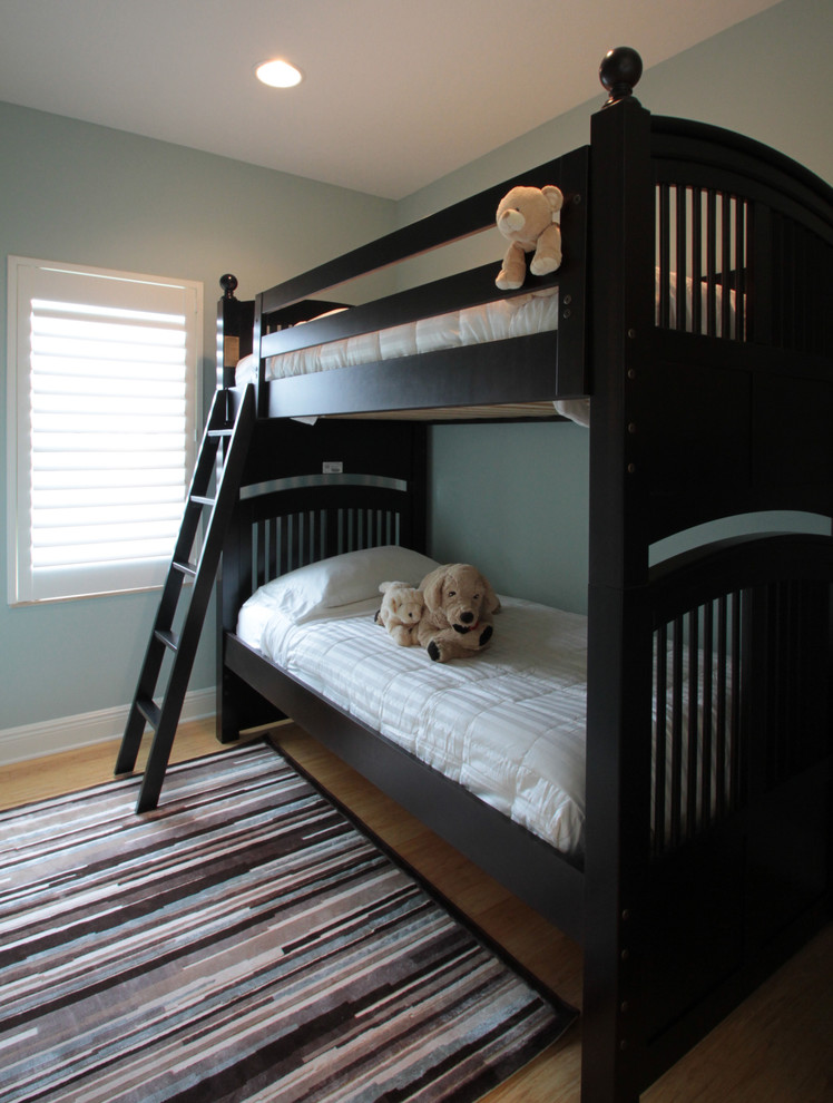 Modelo de dormitorio infantil de 4 a 10 años costero de tamaño medio con paredes azules y suelo de madera clara