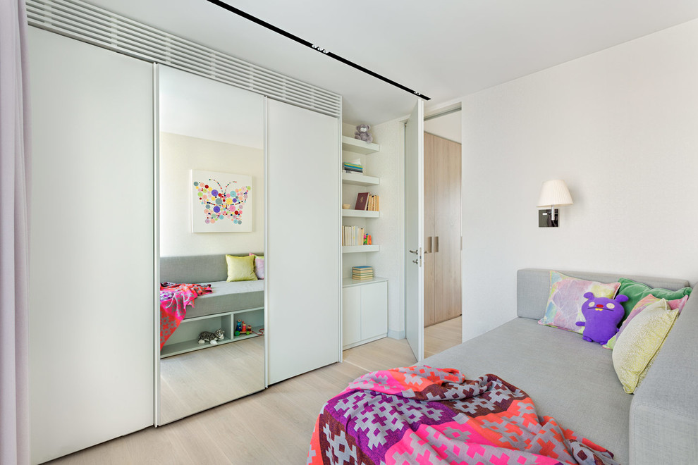 Photo of a contemporary playroom in London with white walls and light hardwood flooring.
