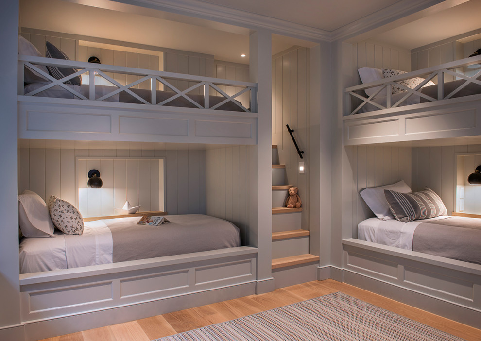 This is an example of a coastal gender neutral kids' bedroom in Providence with grey walls, medium hardwood flooring and brown floors.