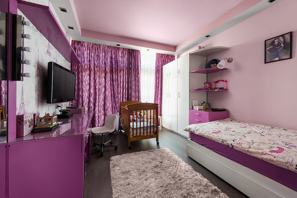 This is an example of a small contemporary children’s room for girls in Other with pink walls and dark hardwood flooring.
