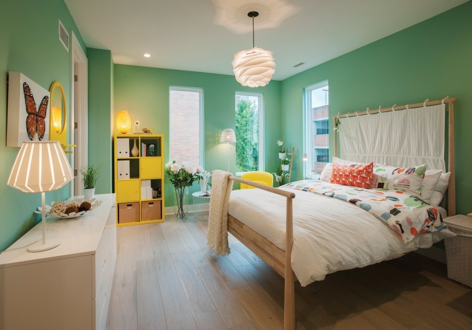 Skandinavisk inredning av ett stort barnrum kombinerat med sovrum, med gröna väggar, mellanmörkt trägolv och brunt golv