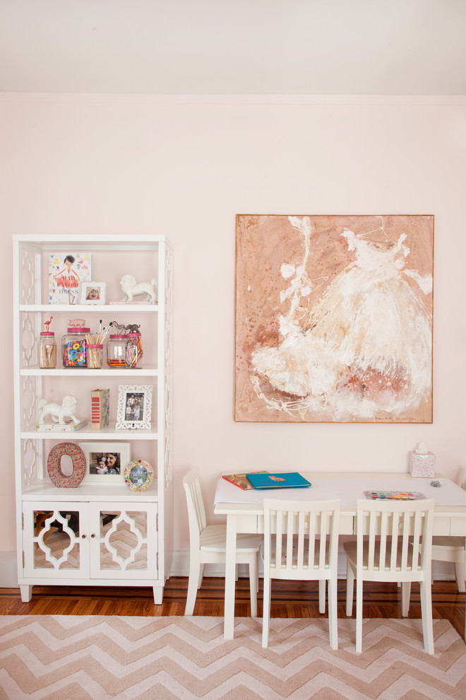 Ejemplo de habitación de niña de 4 a 10 años bohemia con escritorio, paredes rosas y suelo de madera en tonos medios