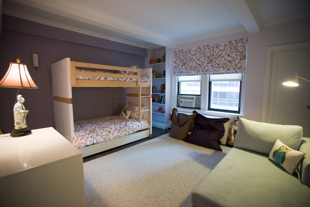 This is an example of a large classic children’s room for girls in New York with pink walls and dark hardwood flooring.