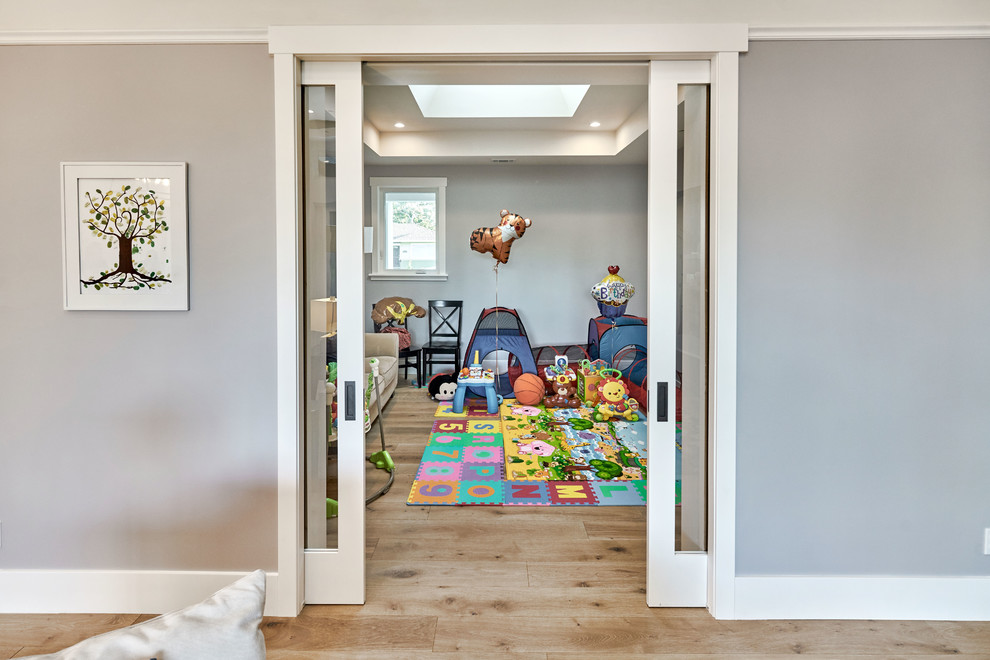 Idéer för mellanstora vintage småbarnsrum kombinerat med lekrum, med grå väggar, ljust trägolv och brunt golv
