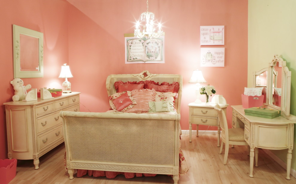 Classic children’s room for girls in Miami with pink walls and light hardwood flooring.