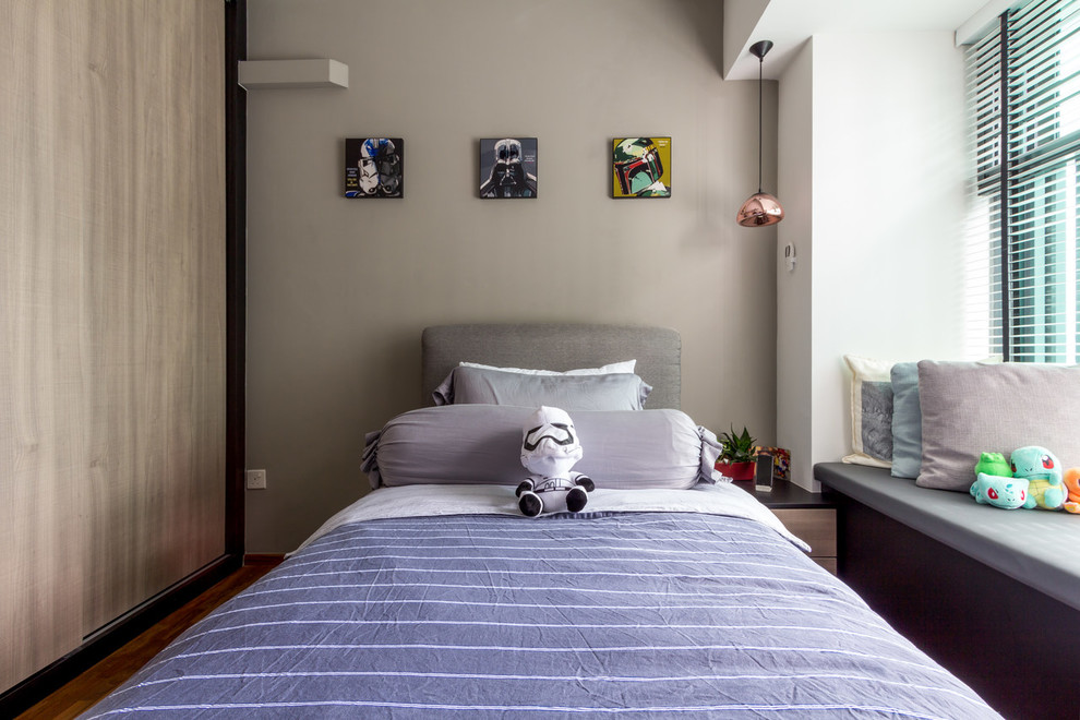 Immagine di una cameretta da letto contemporanea con pareti grigie, pavimento in legno massello medio e pavimento marrone
