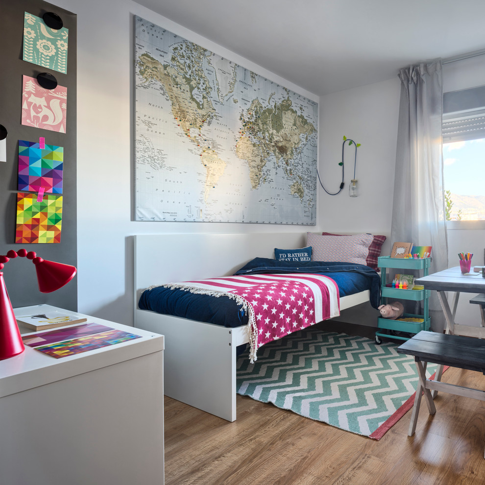 Foto på ett mellanstort eklektiskt könsneutralt barnrum kombinerat med sovrum och för 4-10-åringar, med vita väggar och mellanmörkt trägolv