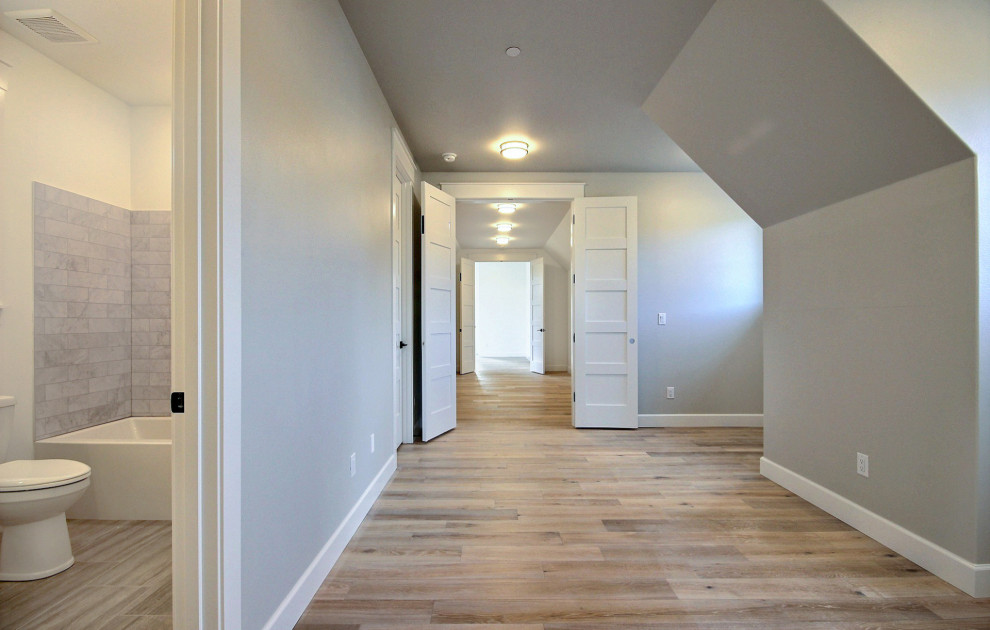 Playroom - huge country gender-neutral light wood floor and brown floor playroom idea in Portland with gray walls
