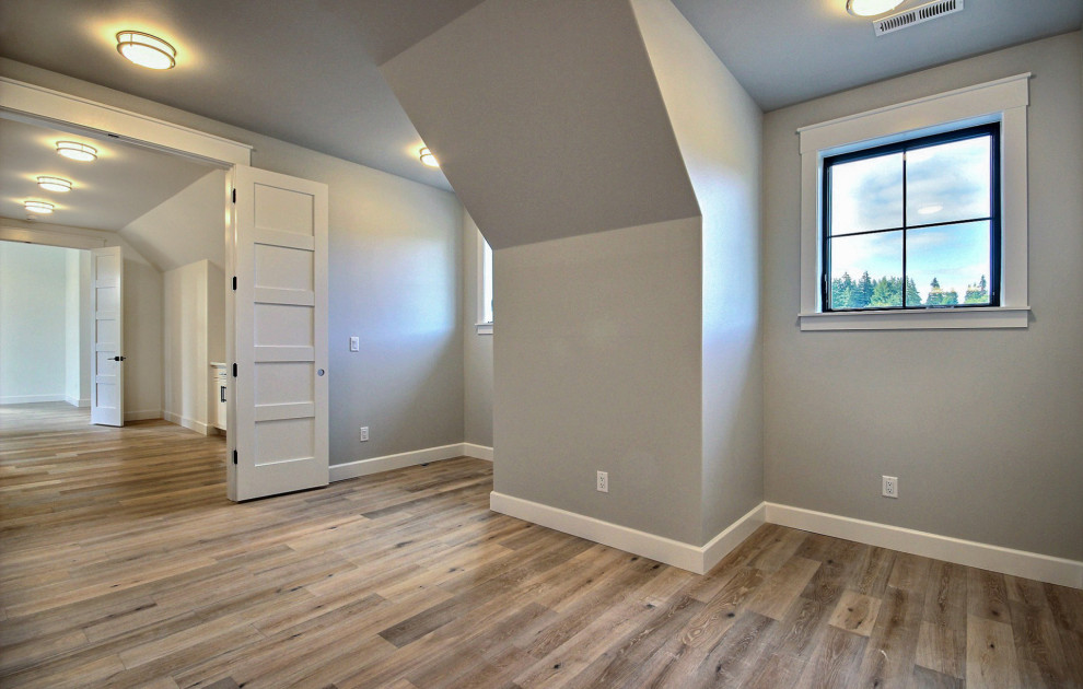 Foto de dormitorio infantil campestre extra grande con paredes grises, suelo de madera clara y suelo marrón