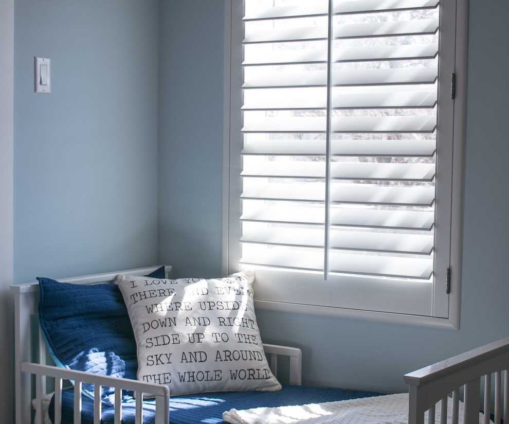 Cette photo montre une chambre de garçon de 1 à 3 ans chic avec un mur bleu.