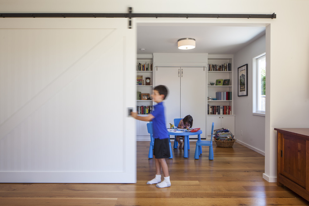 Réalisation d'une chambre d'enfant design avec un mur blanc et un sol en bois brun.