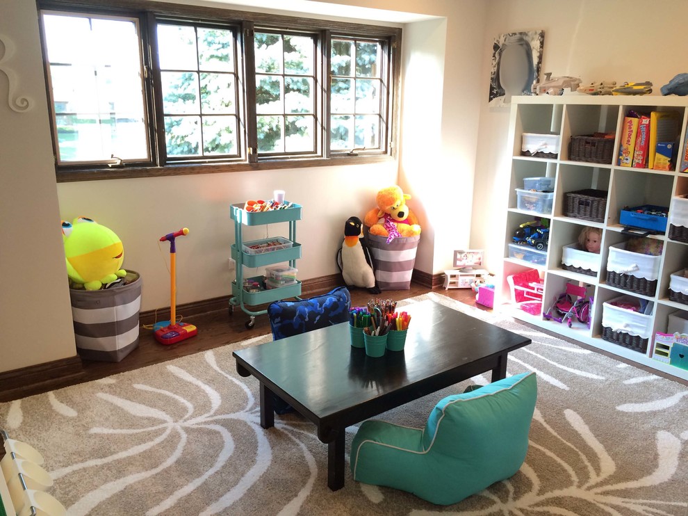 Esempio di una cameretta per bambini da 1 a 3 anni classica di medie dimensioni con pareti bianche, pavimento in legno massello medio e pavimento marrone