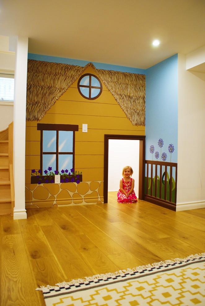 Réalisation d'une chambre d'enfant de 1 à 3 ans bohème avec parquet clair et un mur multicolore.