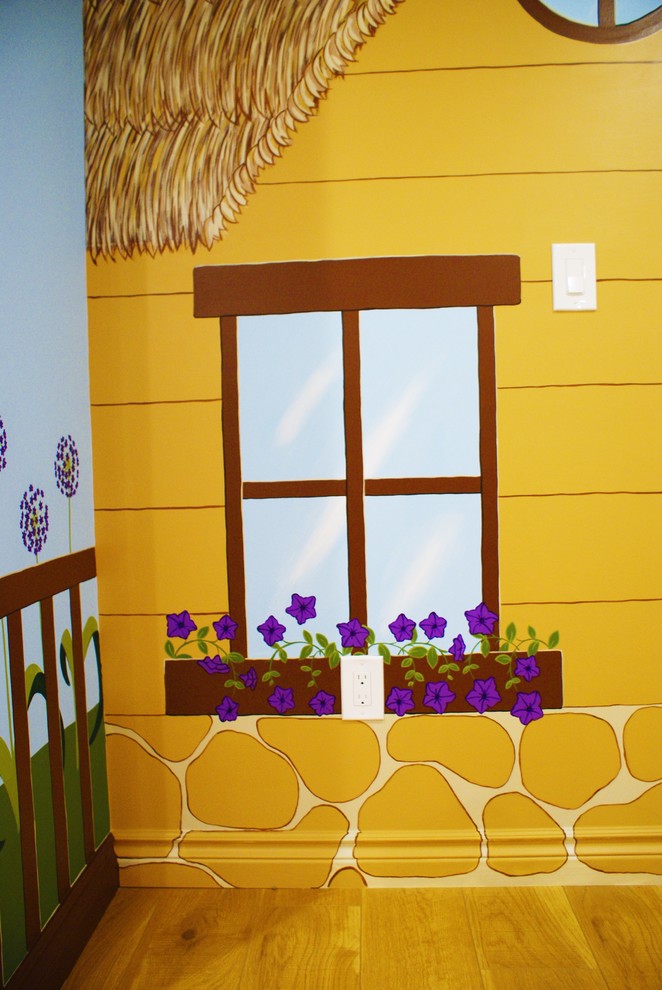 Esempio di una cameretta per bambini da 1 a 3 anni bohémian con parquet chiaro e pareti multicolore