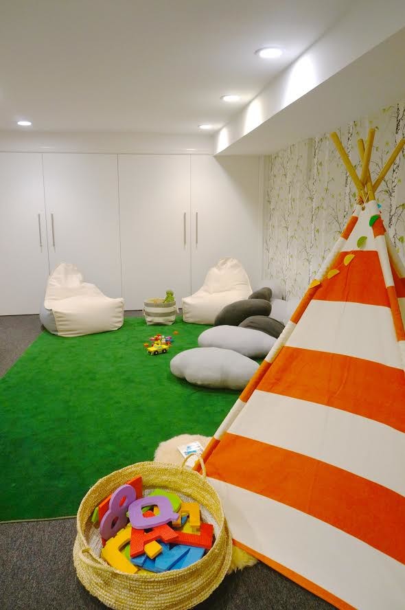 Example of a mid-sized minimalist gender-neutral carpeted kids' room design in New York with white walls