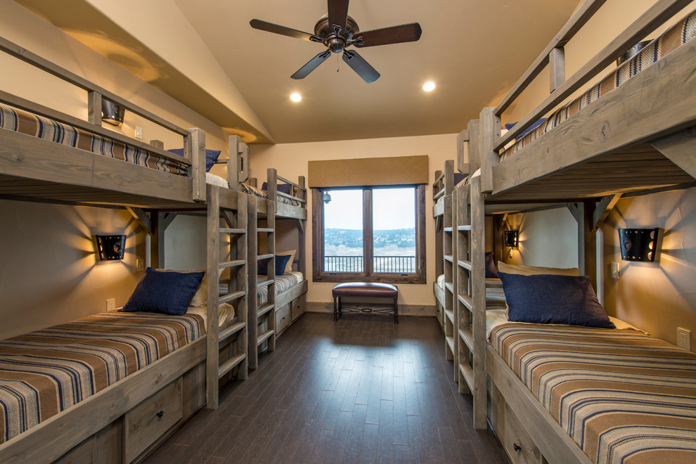 Imagen de dormitorio infantil rural con paredes beige y suelo de madera oscura