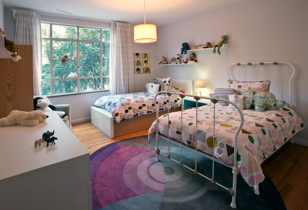 Diseño de dormitorio infantil de 4 a 10 años bohemio con paredes blancas y suelo de madera en tonos medios