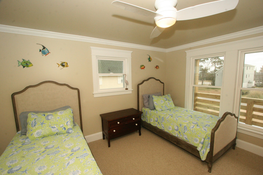 Ejemplo de dormitorio infantil de 4 a 10 años costero de tamaño medio con paredes amarillas y moqueta