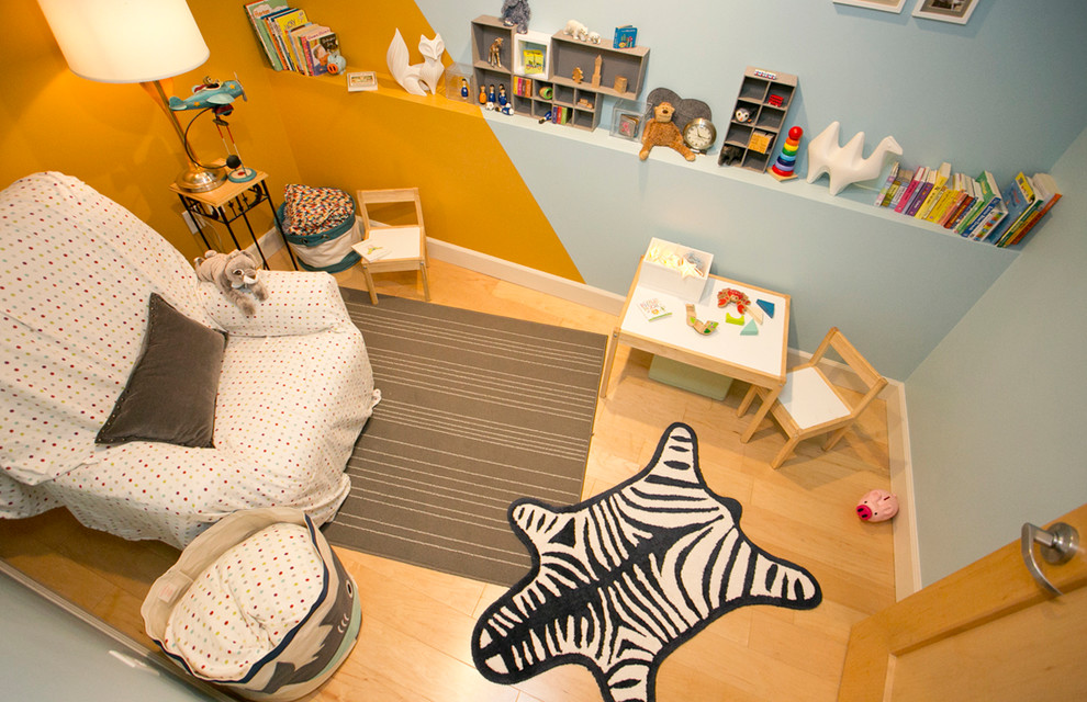 Idée de décoration pour une petite chambre d'enfant de 1 à 3 ans design avec parquet clair, un sol marron et un mur multicolore.
