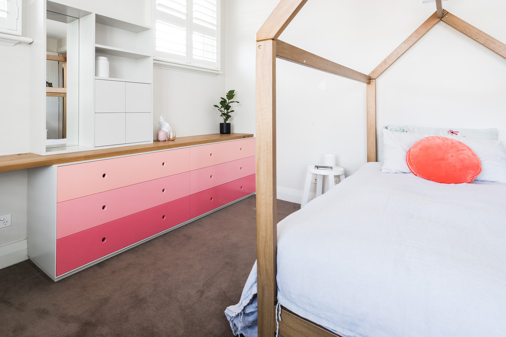 На фото: детская в современном стиле с спальным местом, белыми стенами, ковровым покрытием и коричневым полом с