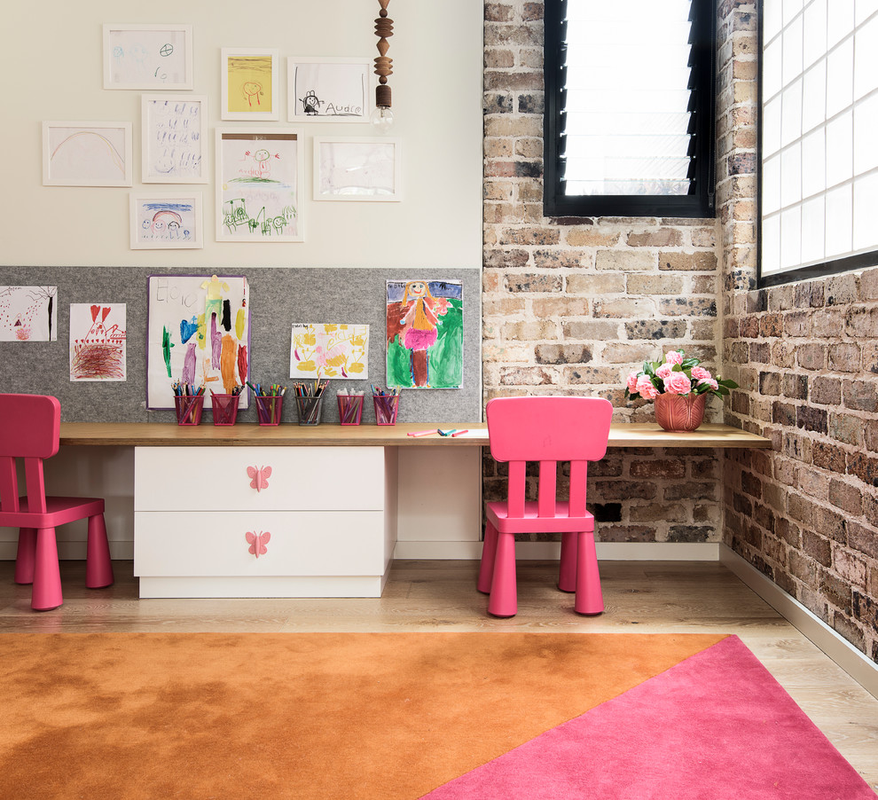 This is an example of an industrial kids' bedroom for girls in Sydney with light hardwood flooring and multi-coloured walls.
