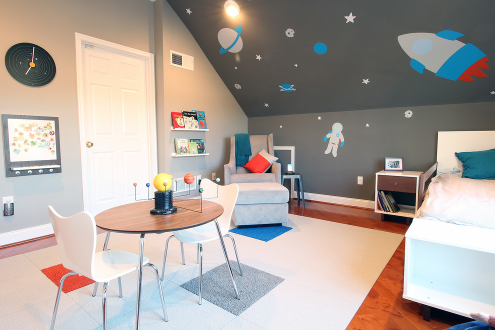 Imagen de dormitorio infantil de 1 a 3 años actual de tamaño medio con paredes grises y suelo de madera en tonos medios