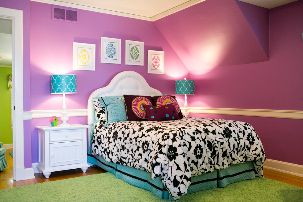 Cette photo montre une chambre d'enfant tendance de taille moyenne avec un mur violet et un sol en bois brun.