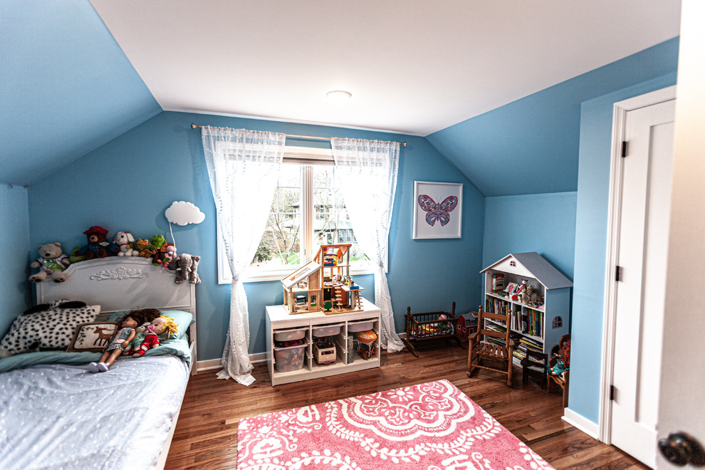 Esempio di una cameretta per bambini tradizionale di medie dimensioni con pareti blu, pavimento in legno massello medio e pavimento marrone