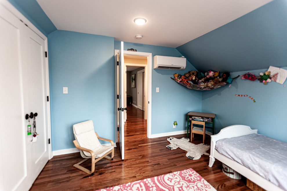 Immagine di una cameretta per bambini tradizionale di medie dimensioni con pareti blu, pavimento in legno massello medio e pavimento marrone