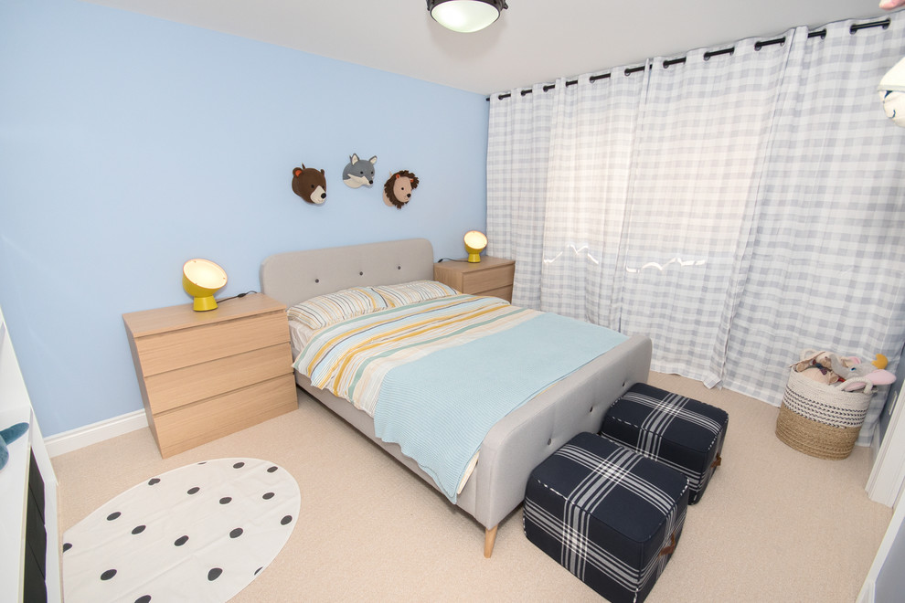 Foto di una cameretta per bambini da 4 a 10 anni minimal di medie dimensioni con pareti blu, moquette e pavimento beige