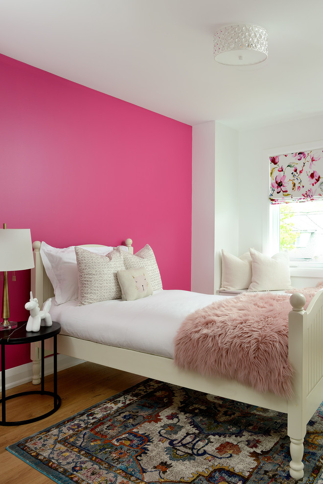 Imagen de dormitorio infantil actual con paredes rosas, suelo de madera en tonos medios y suelo marrón