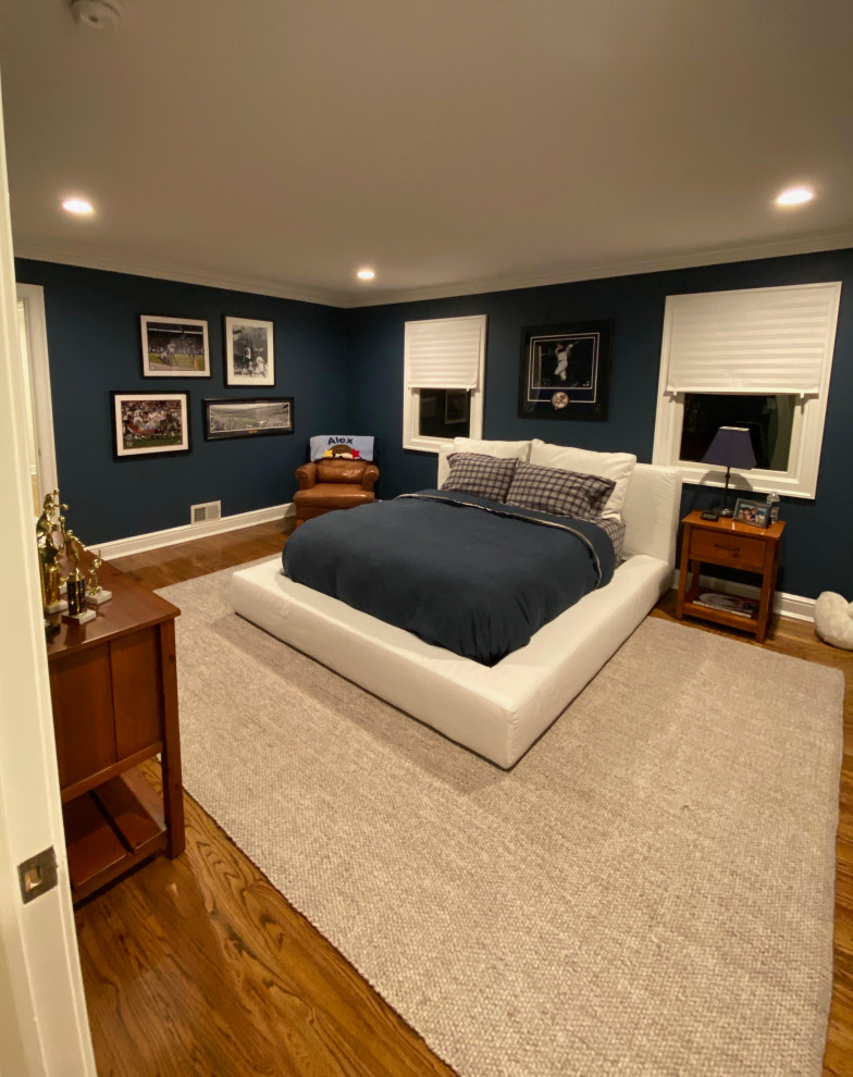 Immagine di una grande cameretta per bambini classica con pareti blu, pavimento in legno massello medio e pavimento marrone