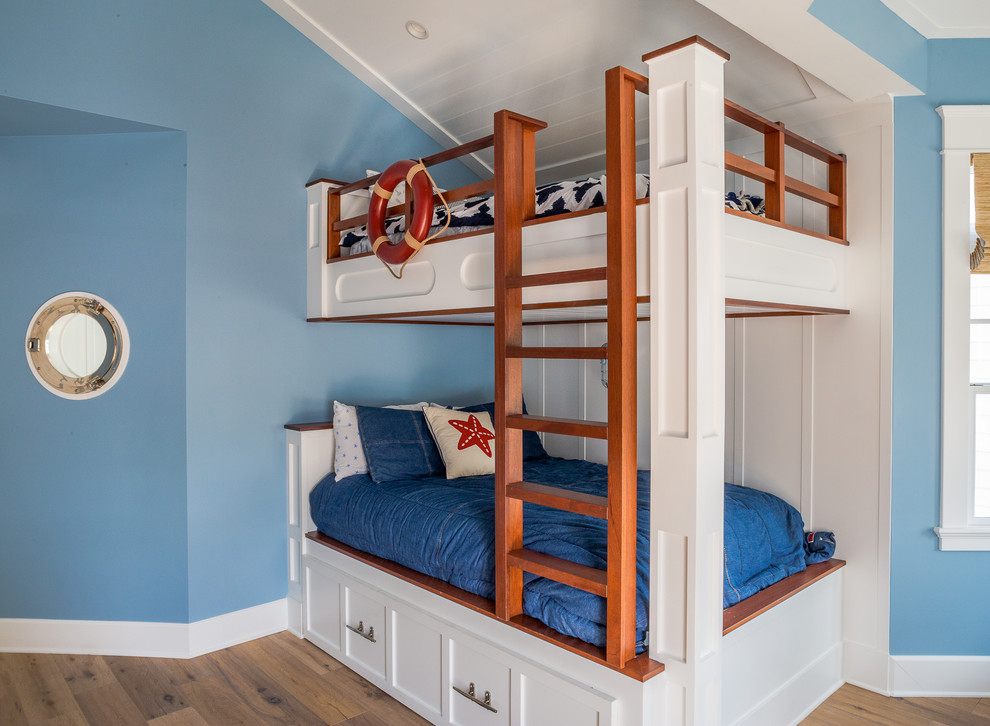 Aménagement d'une petite chambre d'enfant bord de mer avec un mur bleu, parquet clair et un sol gris.