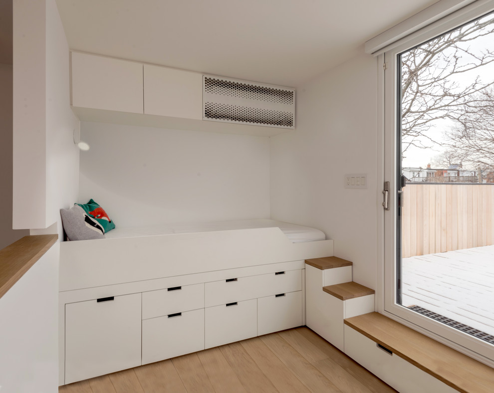 Immagine di una cameretta per bambini da 4 a 10 anni minimalista con pareti bianche e parquet chiaro