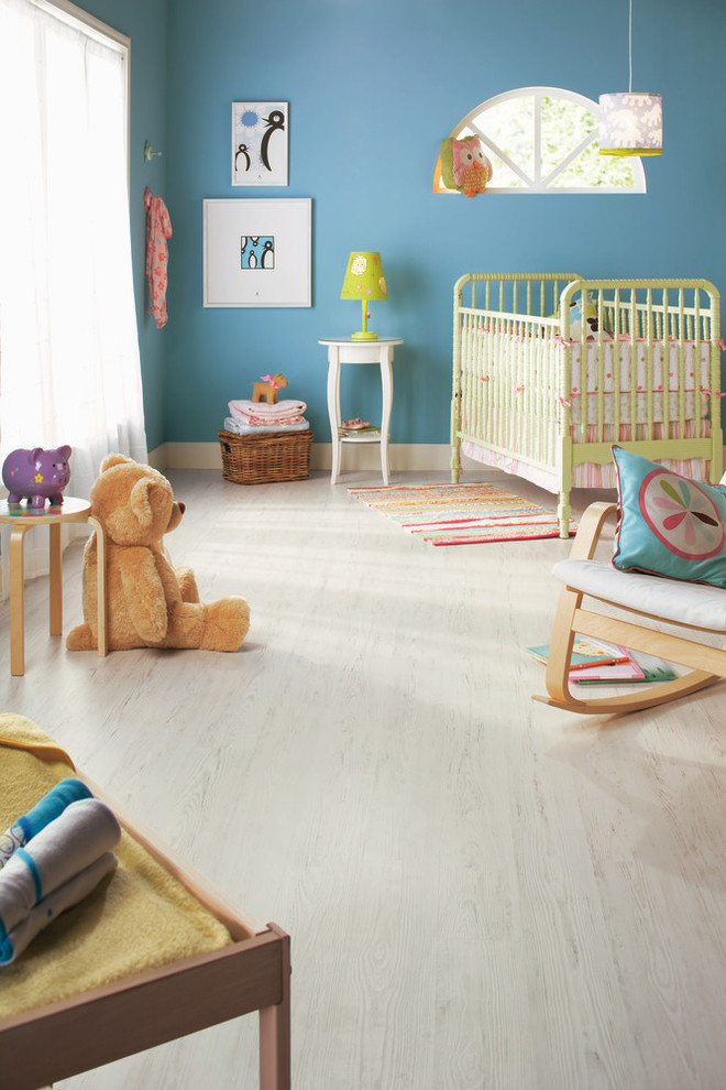 Immagine di una cameretta per bambini da 1 a 3 anni moderna di medie dimensioni con pareti blu e parquet chiaro