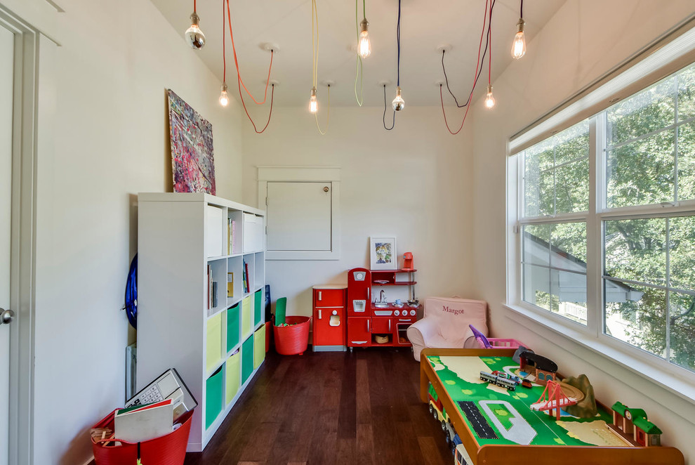 Bild på ett lantligt könsneutralt barnrum kombinerat med lekrum och för 4-10-åringar, med vita väggar, mörkt trägolv och brunt golv