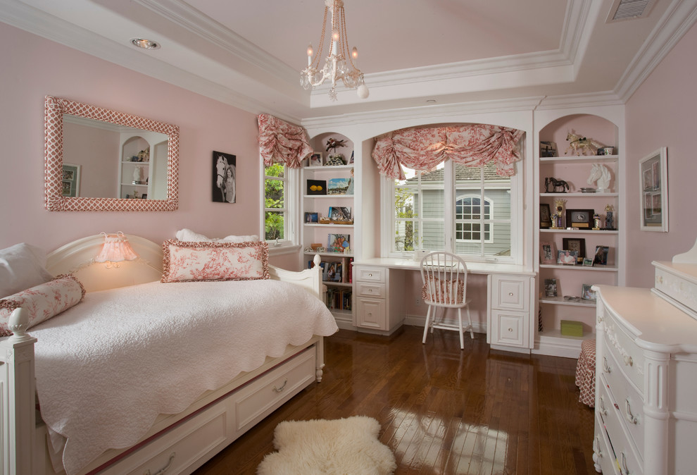 Klassisches Mädchenzimmer mit Schlafplatz, rosa Wandfarbe und braunem Holzboden in Orange County